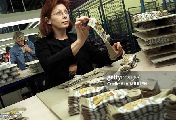 Une employée travaille à l'atelier de finition de la chaine de tissage des chaussettes, le 04 novembre 2002 dans l'usine textile Jacquemard à...