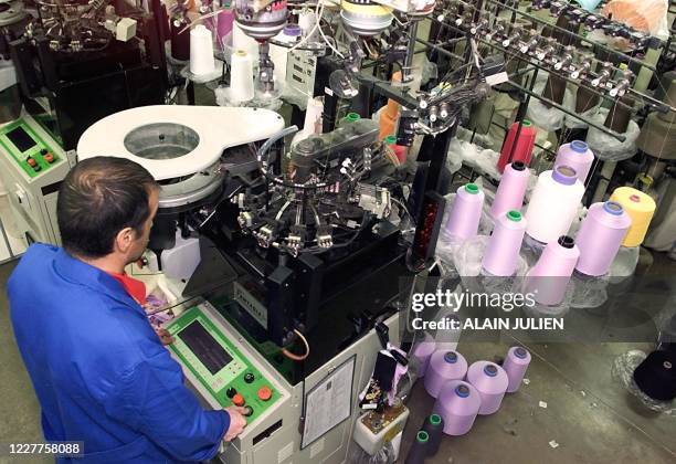 Un employé travaille sur un métier à tisser les chaussettes, le 04 novembre 2002 dans l'usine textile Jacquemard à Romilly. Dans l'Aube, pays de la...