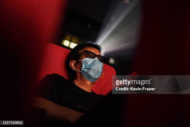 Man wears a protective mask as he watches a movie in 3D at a theatre on the first day they were permitted to open on July 24, 2020 in Beijing, China....