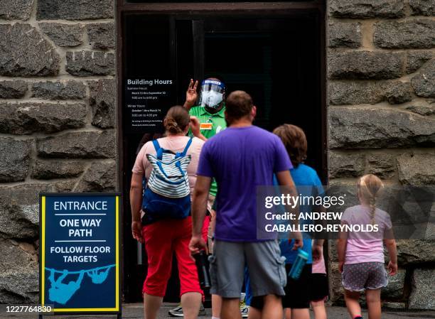 An employee of the zoo controls the number of people entering the primate sanctuary on the opening day of the Smithsonian National Zoo in Washington,...