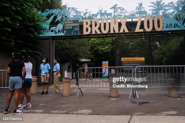 Workers wear protective masks while greeting visitors at the Bronx Zoo in the Bronx borough of New York, U.S., on Friday, July 24, 2020. On Monday,...