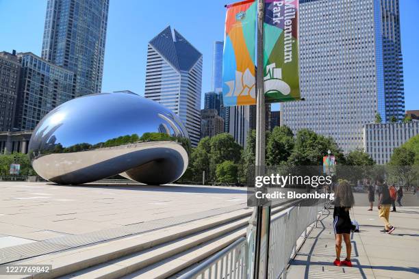 Person takes a photograph of the Cloud Gate sculpture, known as the Bean, at Millennium Park in Chicago, Illinois, U.S., on Friday, July 24, 2020....