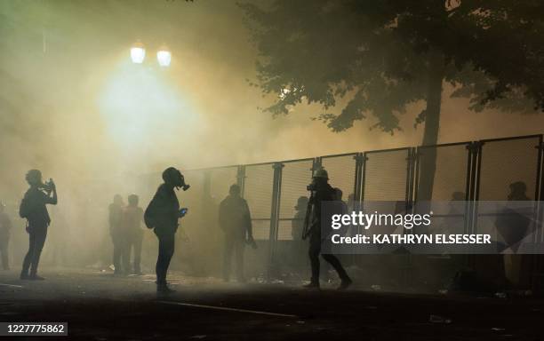 Protesters are surrounded by tear gas near the Mark O. Hatfield federal courthouse in downtown Portland as protesters take part in a rally against...