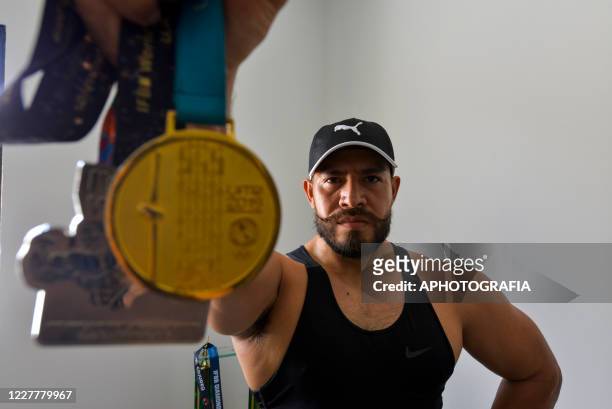 Yuri Rodriguez poses for a portrait while holding his Pan American Games Lima 2019 and World runner-up medals during a training session at his home...