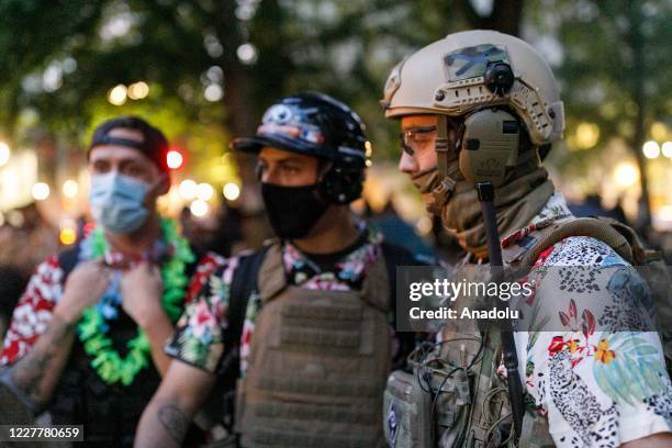 The 'Boogaloo Bois', an armed libertarian group, dress in their signature Hawaiian shirts during a protest on 24, 2020 in Portland, United States....