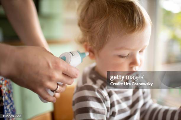 In this photo illustration a mother takes fever of her child on July 24, 2020 in Bonn, Germany.