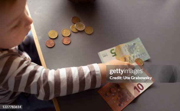 In this photo illustration a child is counting money on July 24, 2020 in Bonn, Germany.