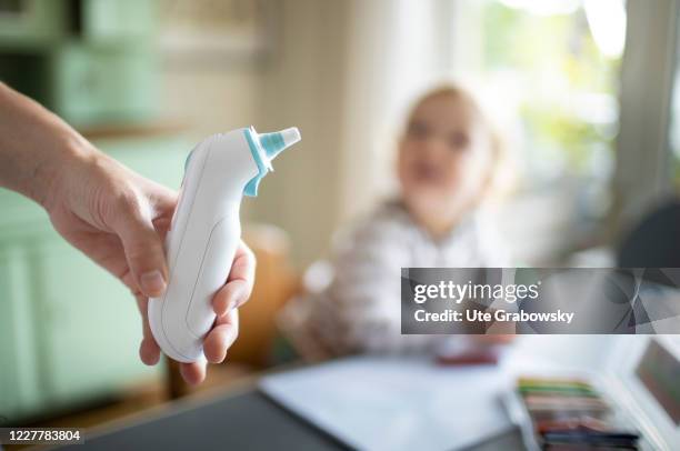 In this photo illustration a mother takes fever of her child on July 24, 2020 in Bonn, Germany.