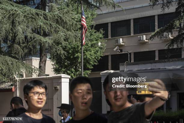 Onlookers pose for a selfie photograph across the street from the U.S. Consulate General Chengdu in Chengdu, China, on Sunday, July 26, 2020....