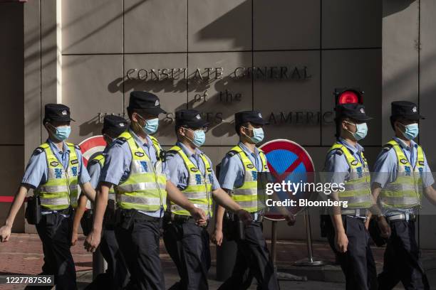 Police officers wearing protective masks walk past the U.S. Consulate General Chengdu in Chengdu, China, on Sunday, July 26, 2020. The closure of the...