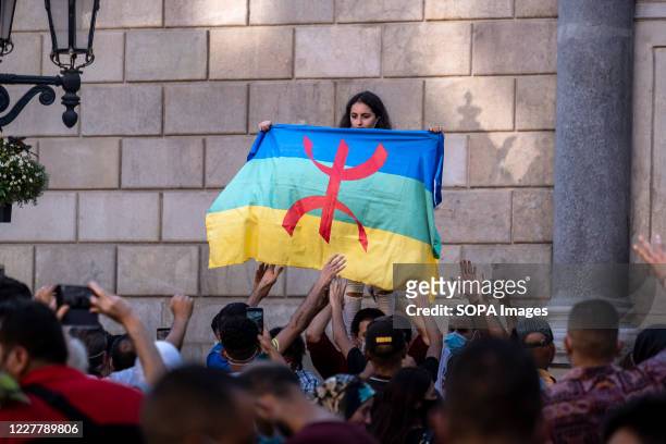 Young girl sympathizing with the Popular Rif Movement is seen unfurling the flag of the Amazigh people known as "Berbers" in North Africa....