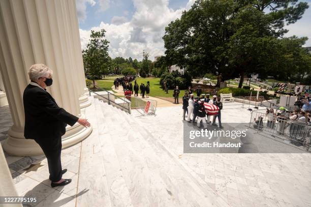 In this handout image provided by the Alabama Governor's Office, Gov. Kay Ivey awaits the arrival of the casket bearing the remains of civil rights...