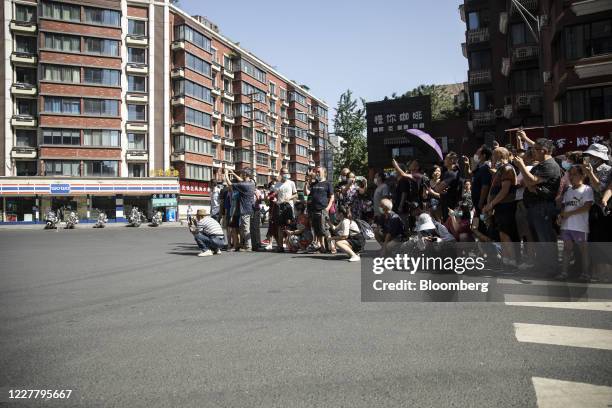 Onlookers gather to observe at a road block near the U.S. Consulate General in Chengdu, China, on Monday, July 27, 2020. The U.S. Lowered its flag...