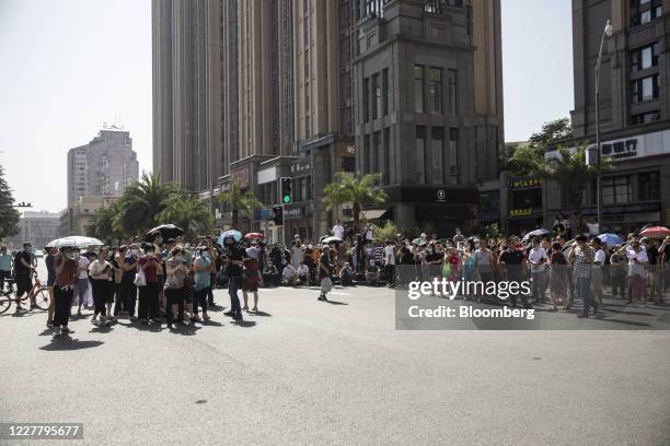 Onlookers gather to observe at a road block near the U.S. Consulate General in Chengdu, China, on Monday, July 27, 2020. The U.S. Lowered its flag...