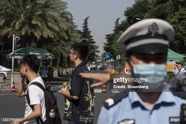 Police officers direct pedestrians at a road block near the U.S. Consulate General in Chengdu, China, on Monday, July 27, 2020. The U.S. Lowered its...