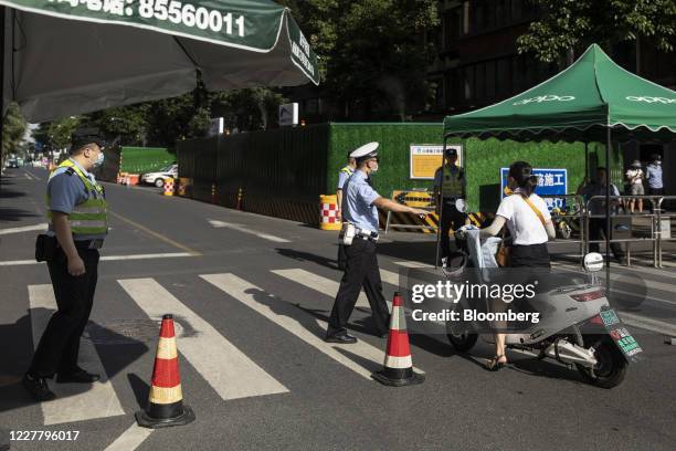 Police officers approach a motorcyclist at a road block near the U.S. Consulate General in Chengdu, China, on Monday, July 27, 2020. The U.S. Lowered...