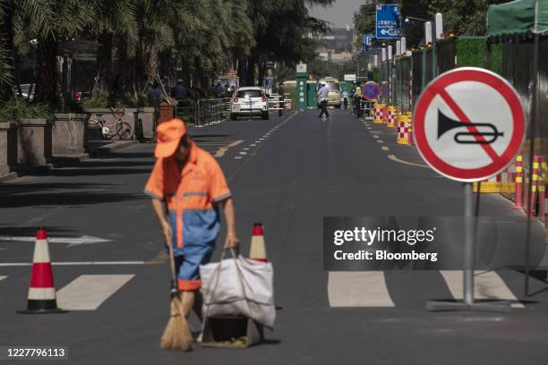 Cleaner sweeps around a road block near the U.S. Consulate General in Chengdu, China, on Monday, July 27, 2020. The U.S. Lowered its flag over the...