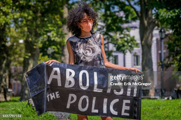 Participant holding an Abolish The Police banner at the protest. Brooklynites gathered at Irving Square Park for a march in the streets of Bushwick,...