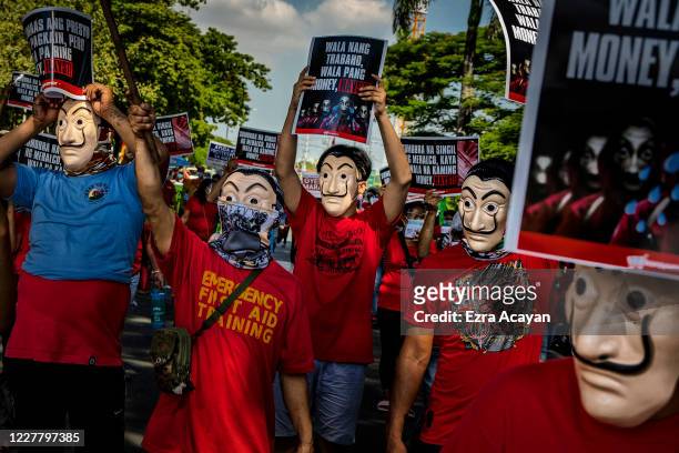 Protesters wearing Salvador Dali masks and carrying signs that read "no jobs no money" take part in a protest against President Duterte on July 27,...