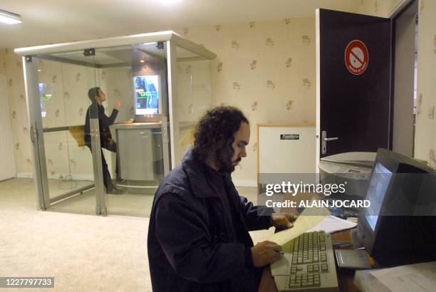 Une personne fume une cigarette dans une cabine pour fumeurs le 10 janvier 2008 à Neuville-De-Poitou près de Poitiers, au sein de la société...