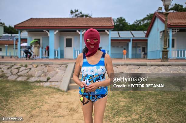This photo taken on July 26, 2020 shows a woman wearing a facekini at the Second Bathing Beach in Qingdao, east China's Shandong Province.