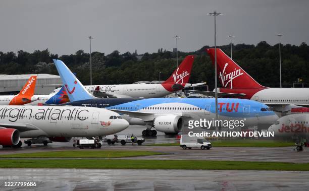 Aircraft operated by TUI, Virgin Atlantic, Easyjet and Jet2, are pictured at Manchester Airport in Manchester, north west England on July 27...