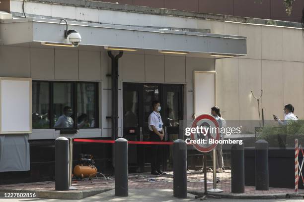 Workers cover up a plaque near the entrance of the vacated U.S. Consulate General in Chengdu, China, on Monday, 27 July 2020. The closure of the U.S....