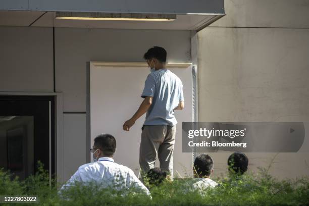 Workers cover up a plaque near the entrance of the vacated U.S. Consulate General in Chengdu, China, on Monday, 27 July 2020. The closure of the U.S....