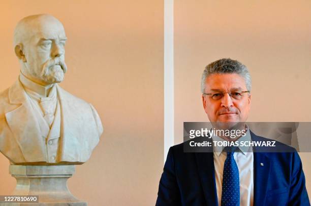 The head of Germany's Robert Koch Institute , Lothar Wieler, poses next to the bust of Robert Koch after addressing a news conference on the...