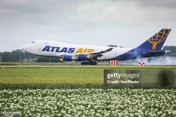 Atlas Air Boeing 747 Freighter, a Cargo aircraft as seen on final approach flying and landing with smoke after the touch down at Amsterdam Schiphol...