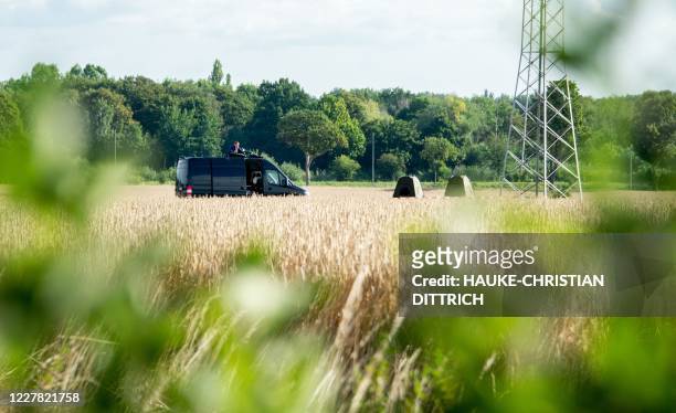 Police car stands in a grain field during a search in a garden allotment in the northern German city of Hanover on July 29 in connection with the...
