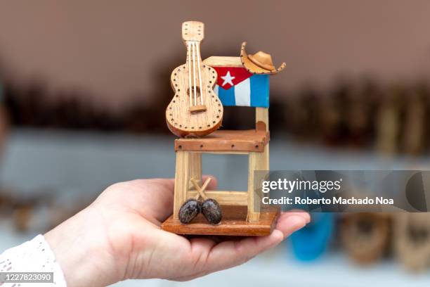 Hands of a woman holding a souvenir with the Cuban flag painted for sale in Cayo Santa Maria.