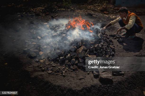 Villagers living around the coal mines in Dhanbad burns coal into pieces of coke, that is sold on the markets as a hot-burning fuel that families can...