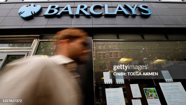 Pedestrian walks past a branch of a Barclays bank in central London on July 29, 2020. - British bank Barclays said Wednesday that first-half net...