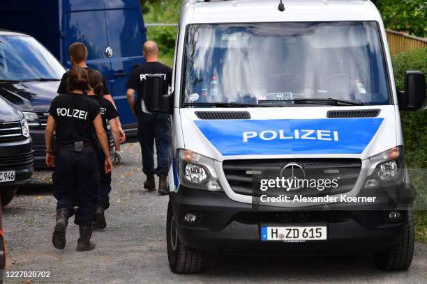 Police forces walk by an allotment garden to continue their search on July 29, 2020 in Hanover, Germany. German Investigators started early for day...