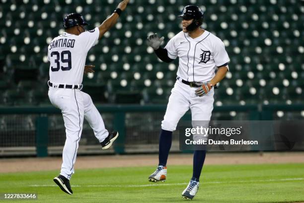 JaCoby Jones of the Detroit Tigers celebrates with third base coach Ramon Santiago after hitting a solo home run against the Kansas City Royals...