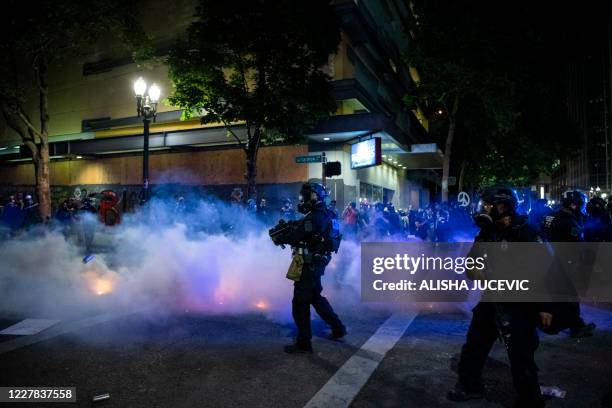 Federal law enforcement throw tear gas at the crowd of demonstrators during a night of protest against racial injustice police brutality and the...