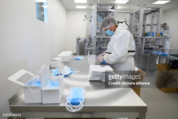 July 2020, Saxony, Ohorn: An employee of PHB Pulsnitzer Hygiene Berufsbekleidung GmbH sorts disposable masks in production. The company from Eastern...