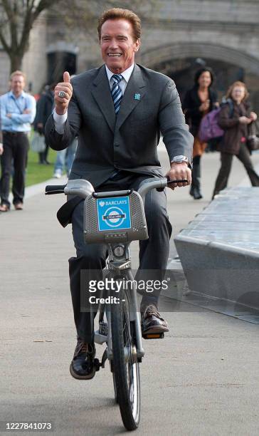 Hollywood star Arnold Schwarzenegger rides a London Cycle Hire Scheme bicycle during a photocall with London Mayor Boris Johnson, in London, on March...