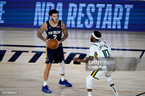 Lonzo Ball looks to pass against Mike Conley of the Utah Jazz at HP Field House at ESPN Wide World Of Sports Complex on July 30, 2020 in Reunion,...