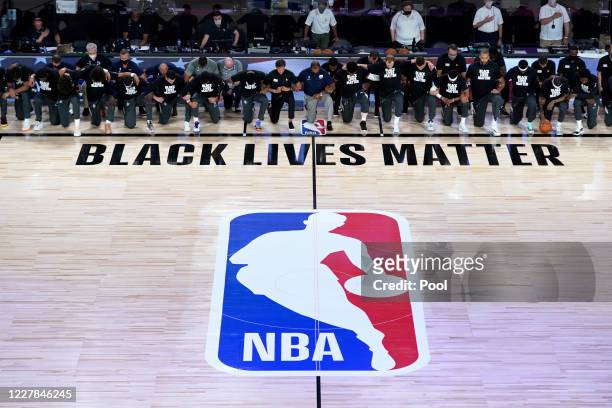 Members of the New Orleans Pelicans and Utah Jazz kneel before a Black Lives Matter logo before the start of their game at HP Field House at ESPN...