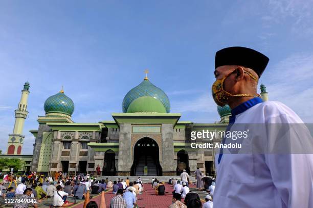 Muslims in Indonesia perform praying Eid al- Adha using face masks and maintaining physical distance amid coronavirus outbreak at An-Nur Grand Mosque...