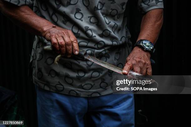 Man cleans a panga as he prepares slaughter a sheep during celebrations for Eid al-Adha. Muslims worldwide mark Eid Al-Adha, to commemorate Prophet...