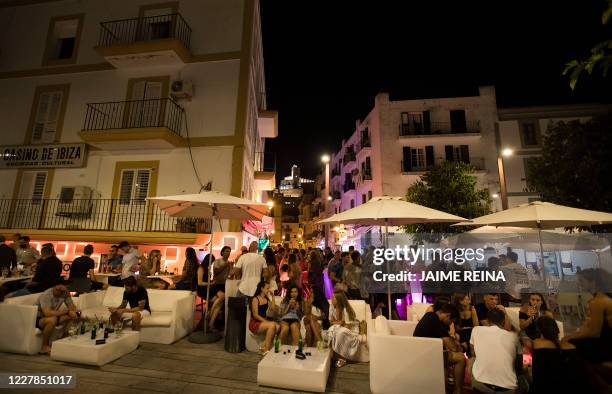 People gather at terrace bar at the port of Ibiza on July 31, 2020. - To curb the spread of coronavirus cases, the regional government of the...