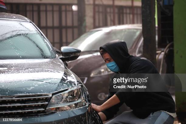 Worker of a car wash carry out their tasks using face masks as a preventive measure in Buenos Aires, Argentina, on July 31, 2020. After more than...