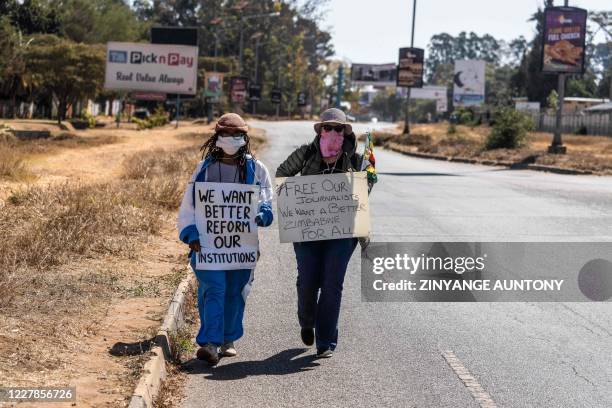 Zimbabwean novelist Tsitsi Dangarembga and a colleague Julie Barnes hold placards during an anti-corruption protest march along Borrowdale road, on...