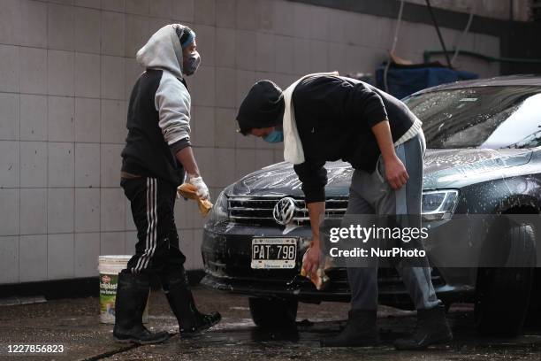 Workers of a car wash carry out their tasks using face masks as a preventive measure in Buenos Aires, Argentina, on July 31, 2020. After more than...