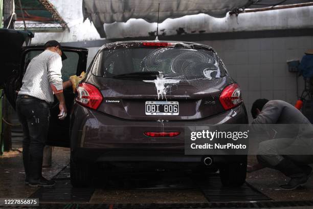 Worker of a car wash carry out their tasks using face masks as a preventive measure in Buenos Aires, Argentina, on July 31, 2020. After more than...