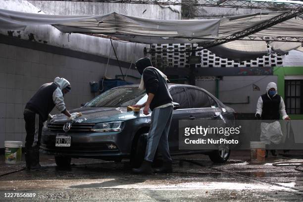Workers of a car wash carry out their tasks using face masks as a preventive measure in Buenos Aires, Argentina, on July 31, 2020. After more than...