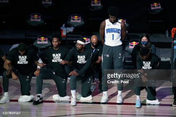 Jonathan Isaac of the Orlando Magic stands as others kneel before the start of a game between the Brooklyn Nets and the Orlando Magic on July 31,...